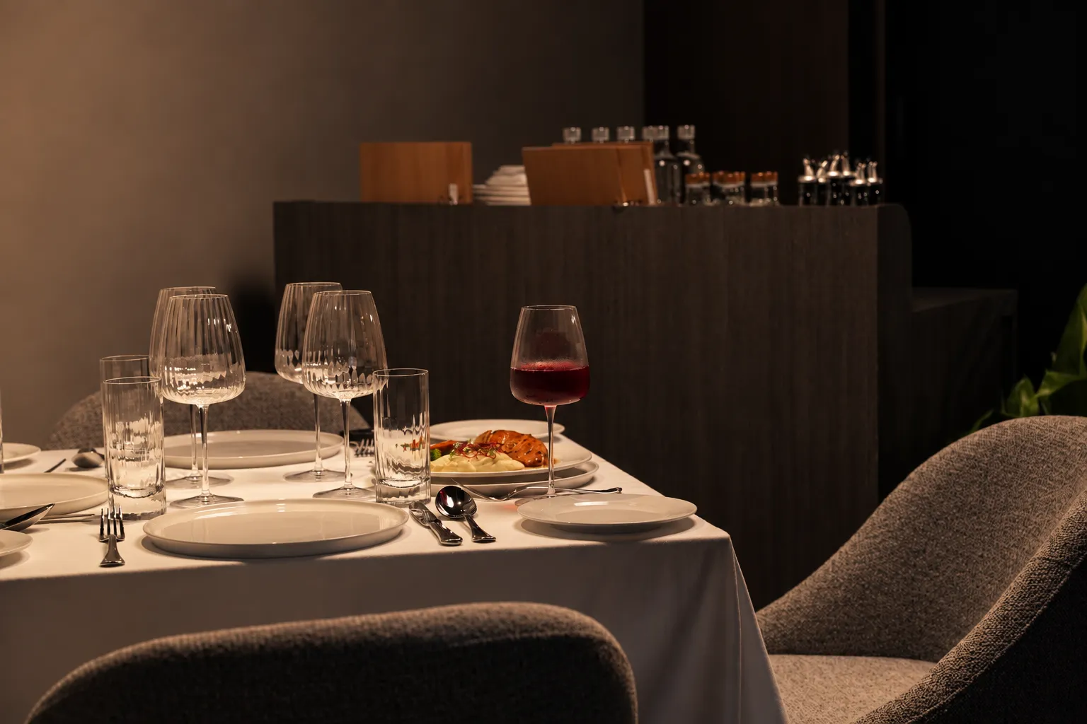 A corner of the dining room with a set table and red wine