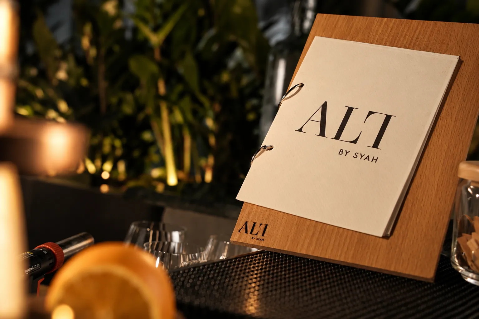 The ALT menu standing on the bar beside a glass and an orange slice