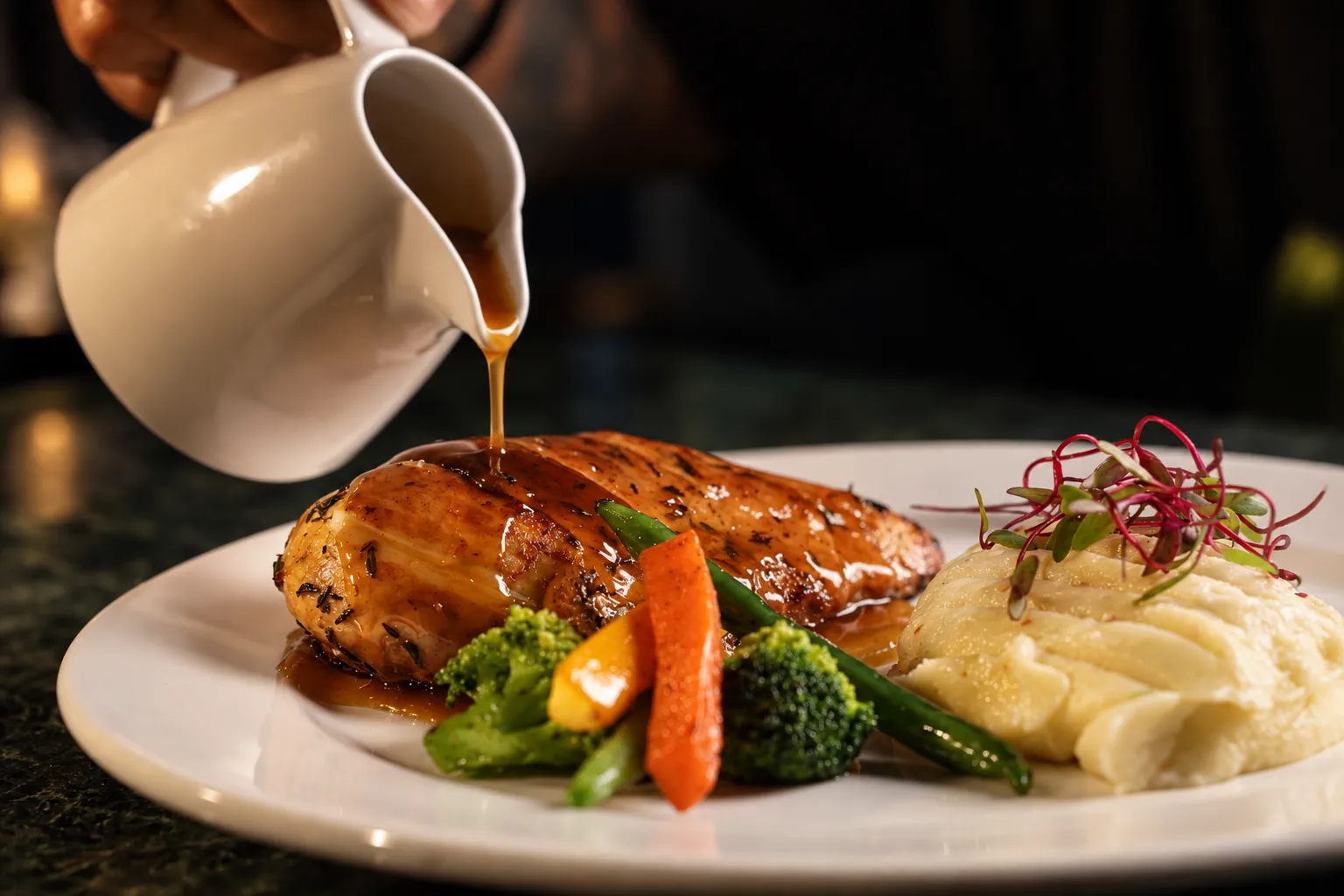 Jus poured over grilled chicken with mash and vegetables